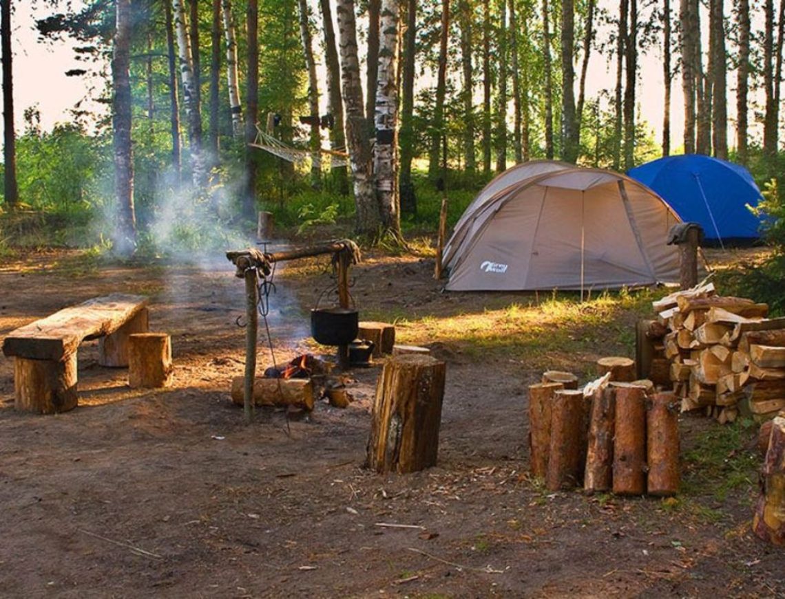По прибытии на поляну мы разбили лагерь. Палаточный лагерь в лесу у реки. Место отдыха в лесу. Обустройство походного лагеря. Туризм с палатками.