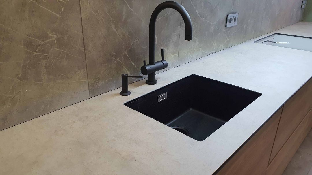 Смеситель и мойка черного цвета на светлой столешнице из HPL плиты