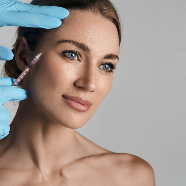 Биоревитализация.Улыбающаяся женщина с молодой и сияющей кожей после процедуры биоревитализации.