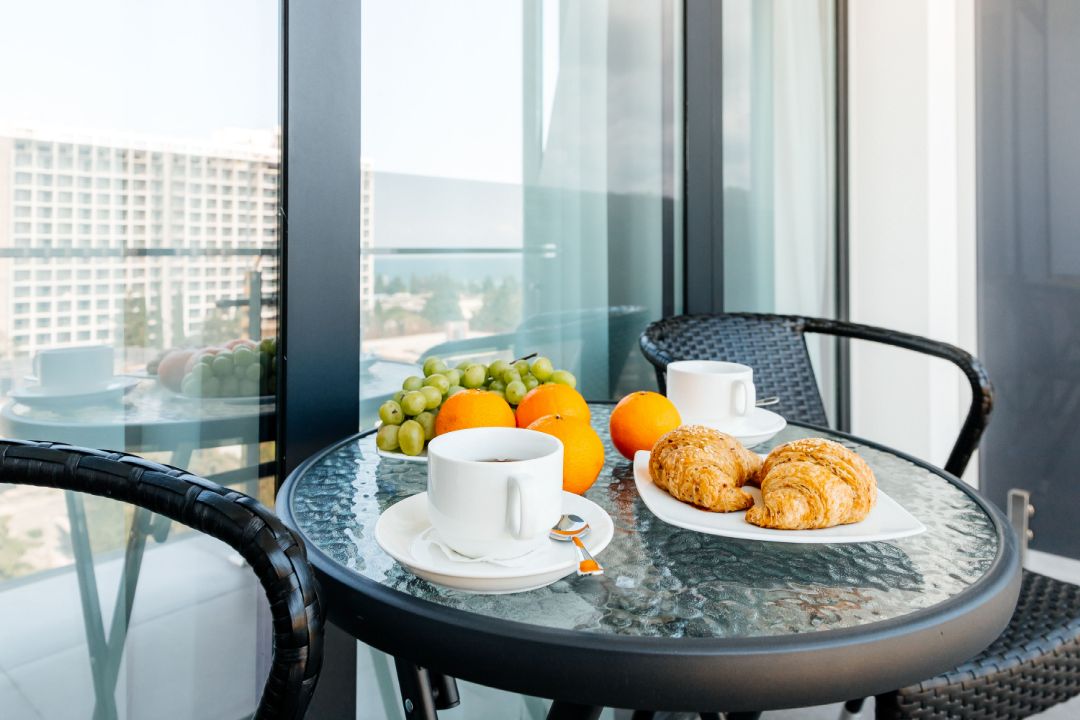 фрукты и выпечка на столе на балконе