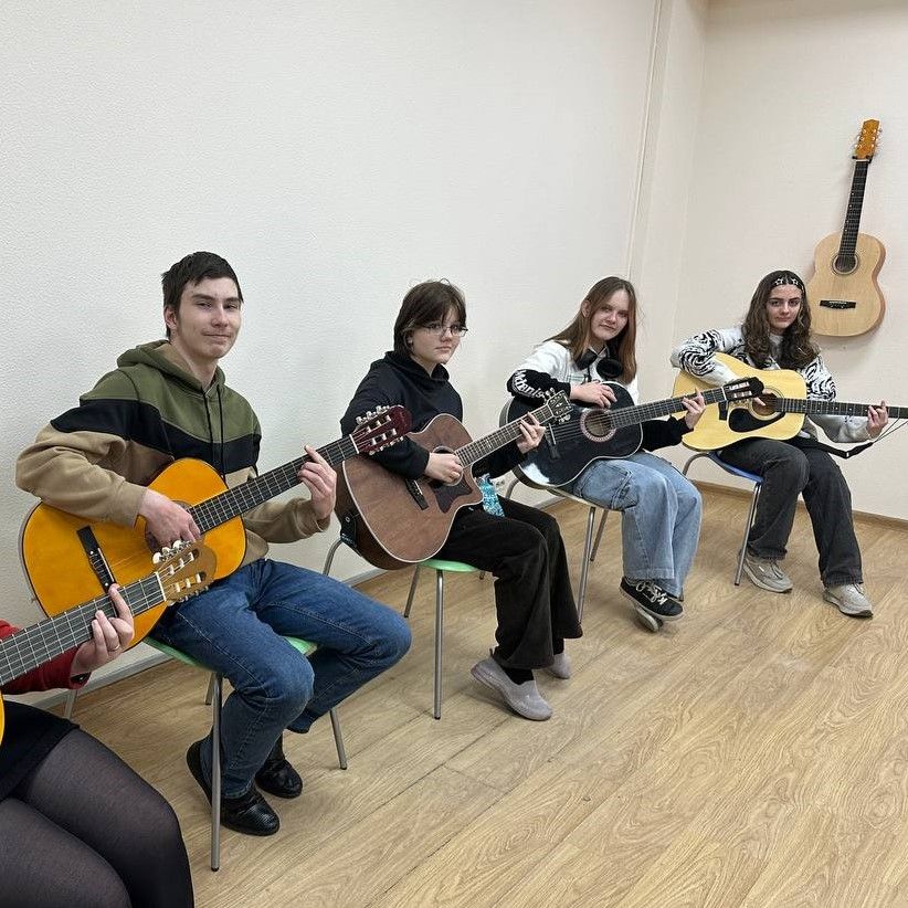 Групповое занятие игре по гитаре, дети готовятся к отчетному концерту