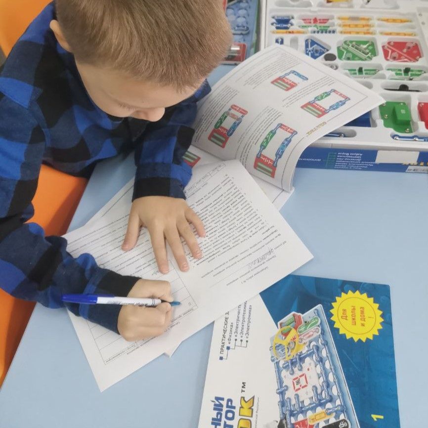 Ученик записывает наблюдения в тетрадь на занятии с набором Знаток