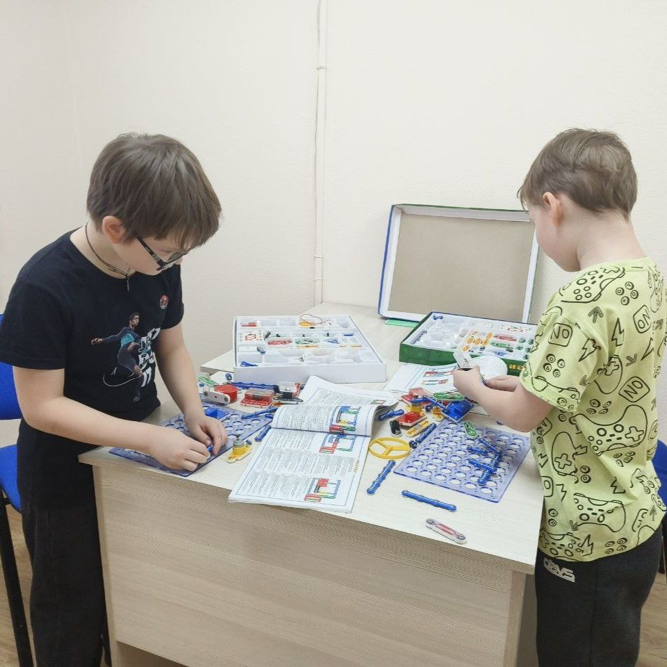 Дети обсуждают и настраивают электронную схему конструктора Знаток