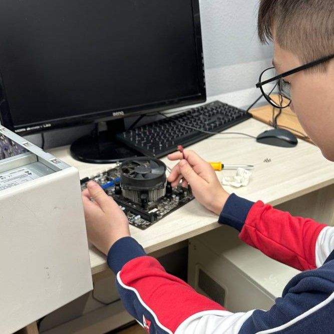 Ученики подключают кабели и провода внутри системного блока на курсе Сисадмин