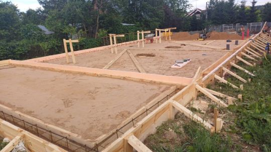 Бригада строителей заливает фундамент дома