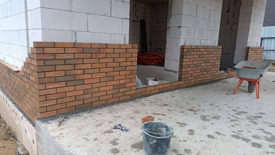 Процесс облицовки двухэтажного дома из газобетона