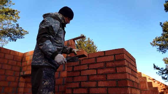 Бригада строителей строит коробку дома из газобетона