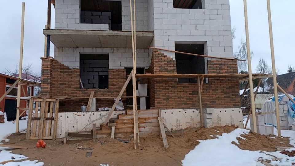 Процесс облицовки двухэтажного дома из газобетона