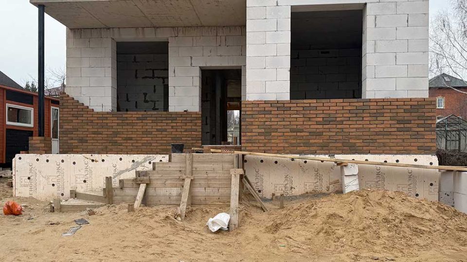 Процесс облицовки двухэтажного дома из газобетона