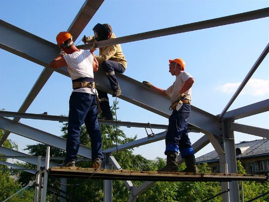 The installation team consists of four people in a green uniform with a construction tool