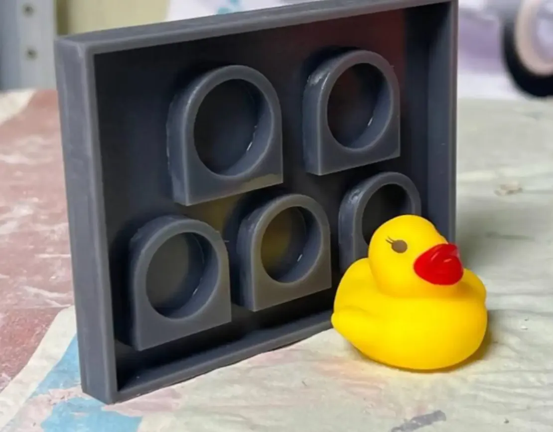 Форма с пятью кольцами из эпоксидной смолы и фигуркой жёлтой утки рядом