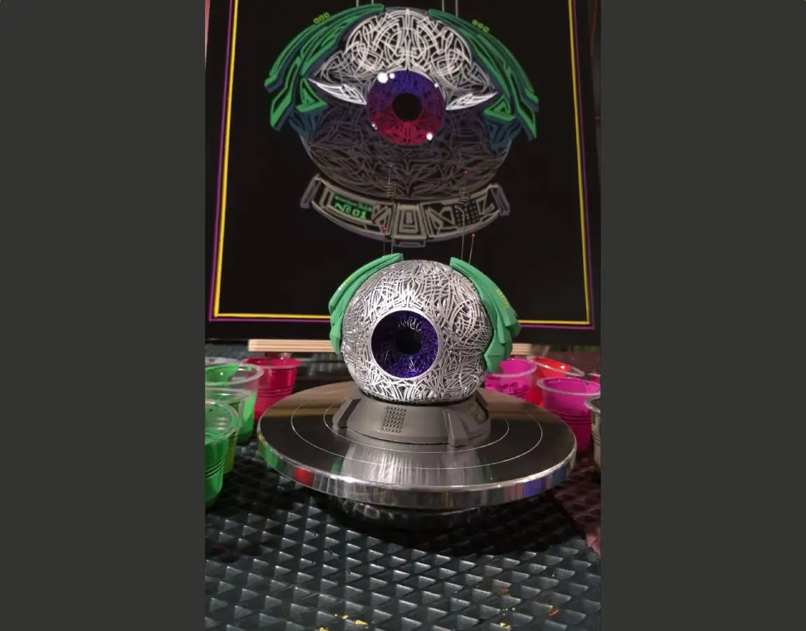 Готовая 3D-фигура глаза с фиолетовым зрачком на фоне концепт-арта и банок с краской