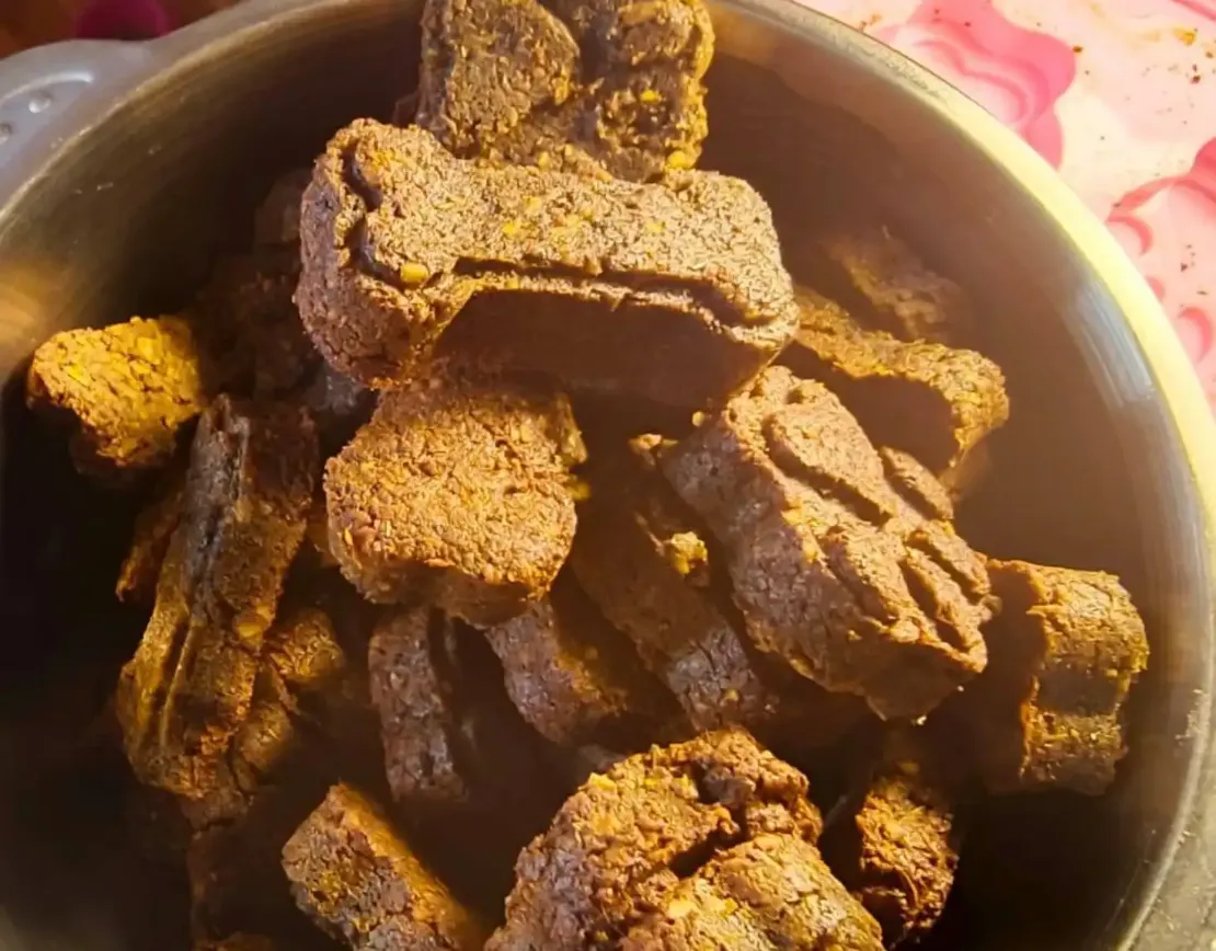 Миска, полная лакомств для собак в виде лапок и косточек