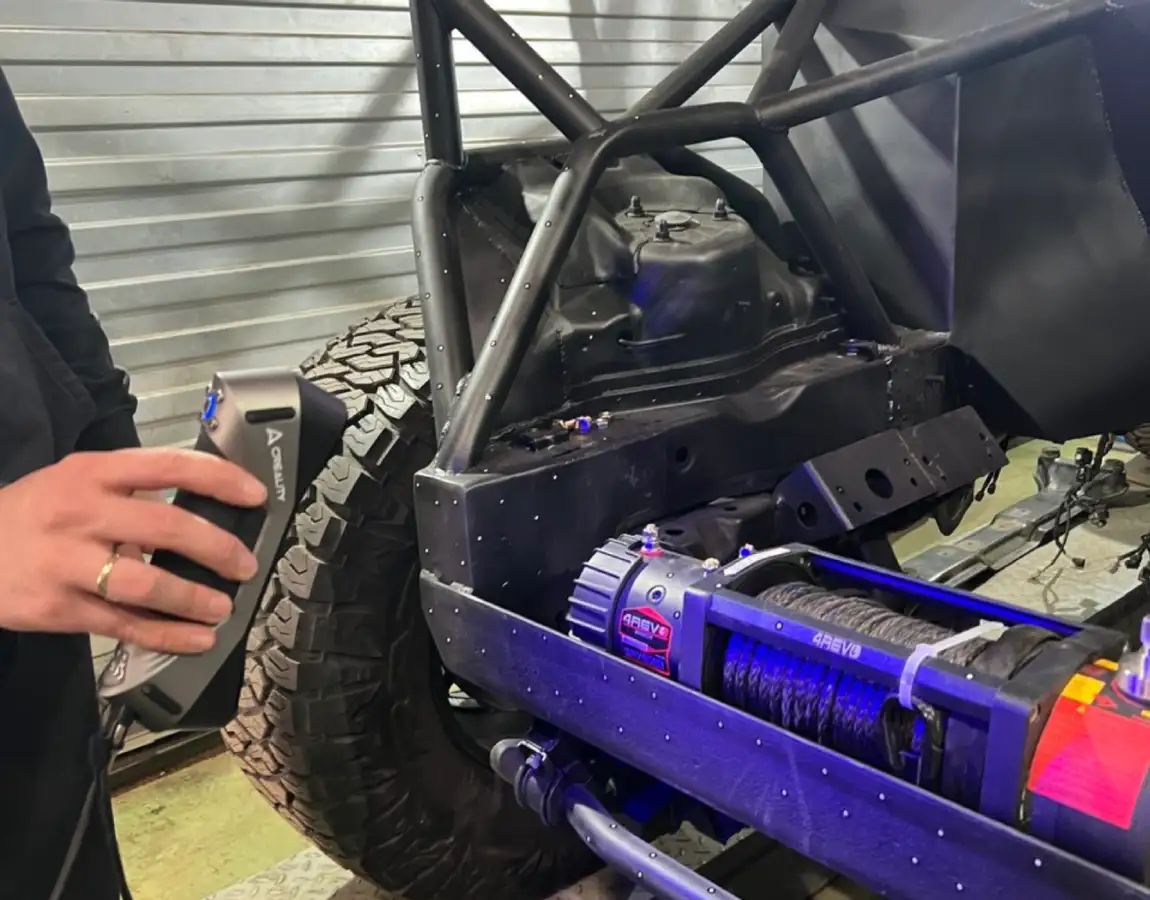 Сканирование задней части автомобиля, видно колесо и каркас рамы.