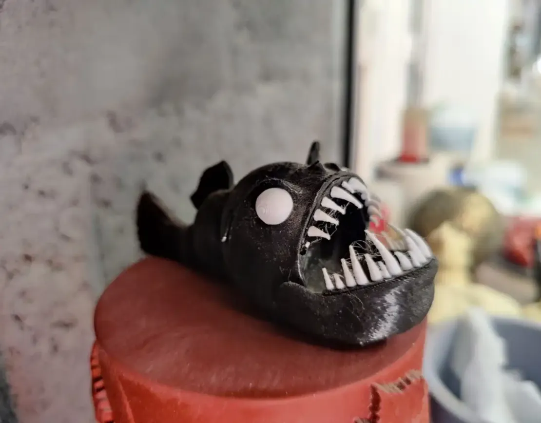 3D-печатная модель рыбы-монстра крупным планом на светлом фоне.