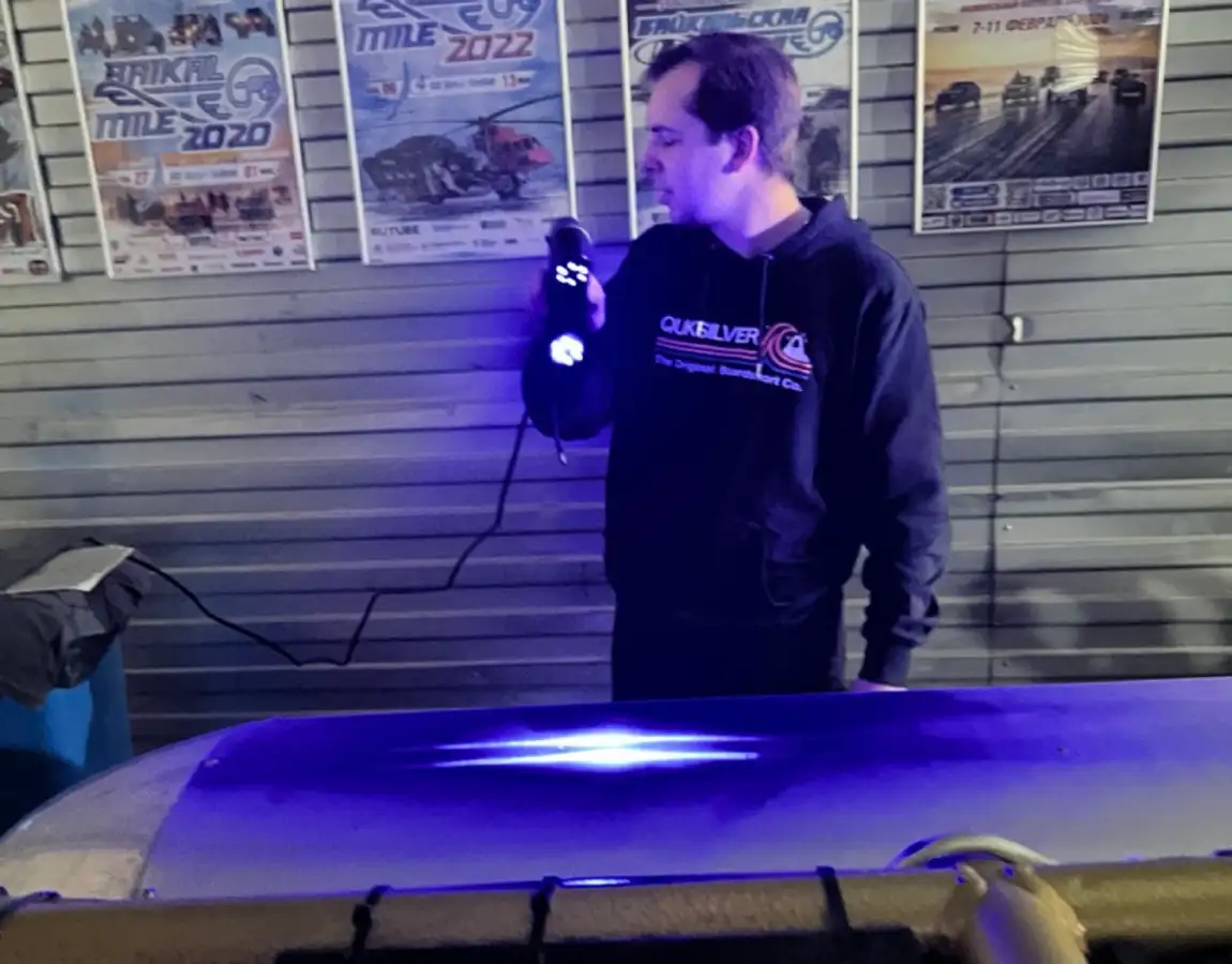 Оператор сканирует аэродинамический обтекатель. Видно фоновое оформление мастерской.