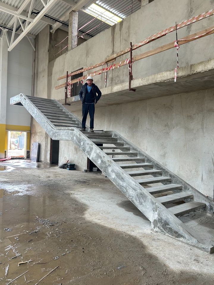 Инженер компании ArtPickUp на готовой бетонной лестнице на косоурах