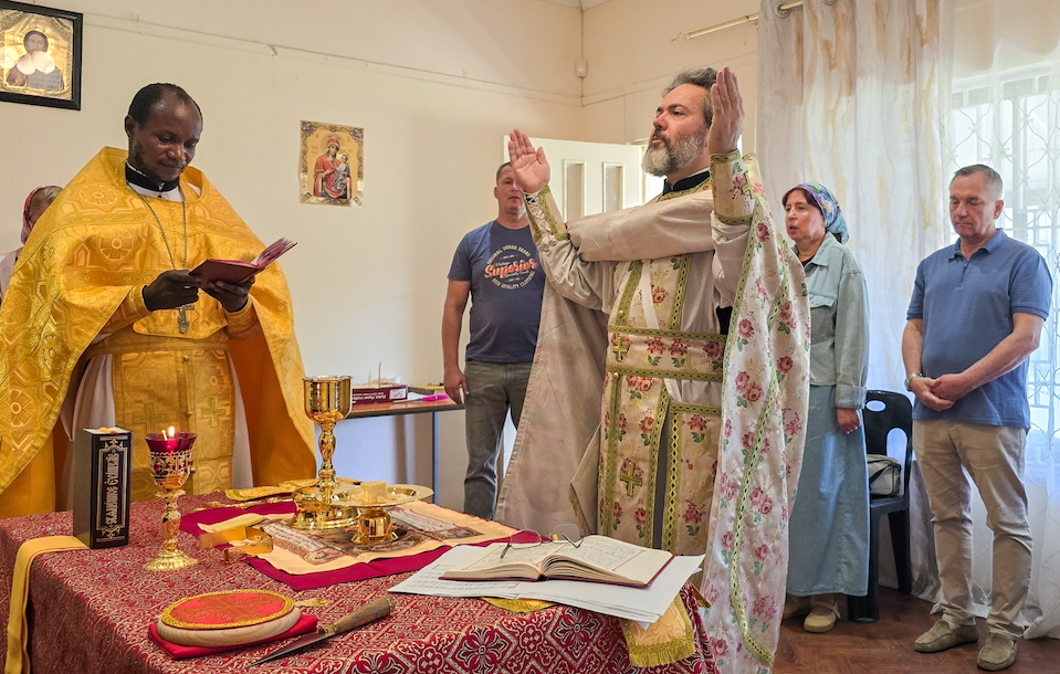 Богослужение в православном храме в Робертсоне, священник у алтаря и прихожане во время литургии.