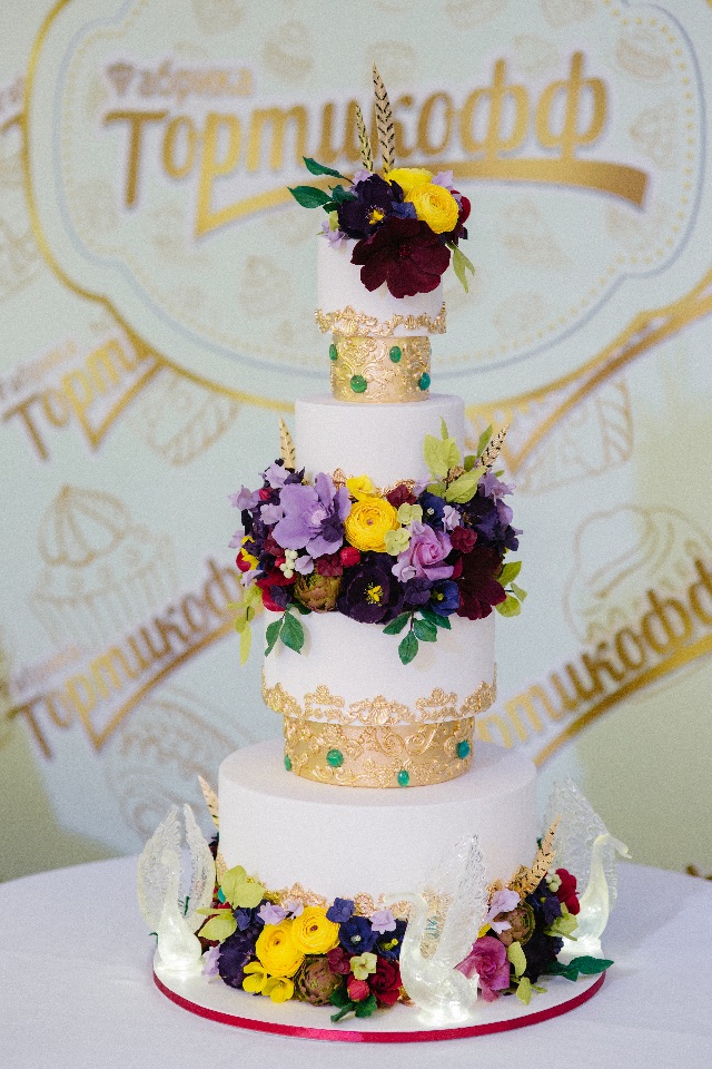 Многоярусный торт с сахарной цветочной композицией ручной работы и светящимися хрустальными лебедями из карамели на заказ в Воронеже